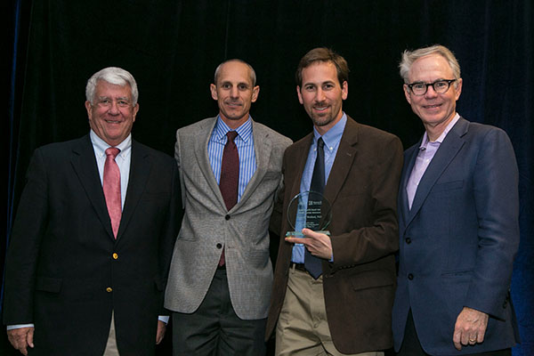 Dr. Welford receiving his award. With him are, left to right, Barry L. Hoeven, founder of Kure It Cancer Research; Todd Perry, board member, Kure It Cancer Research; and Charles L. Sawyers, MD, immediate past president of the AACR.
